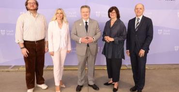 Fünf Personen stehen bei einer offiziellen Präsentation der Plattform wirsindstadt.at vor einem Hintergrund mit dem Logo der Stadt Wien. Die Plattform informiert über Jobs und Lehrstellen in Städten und Gemeinden Österreichs.