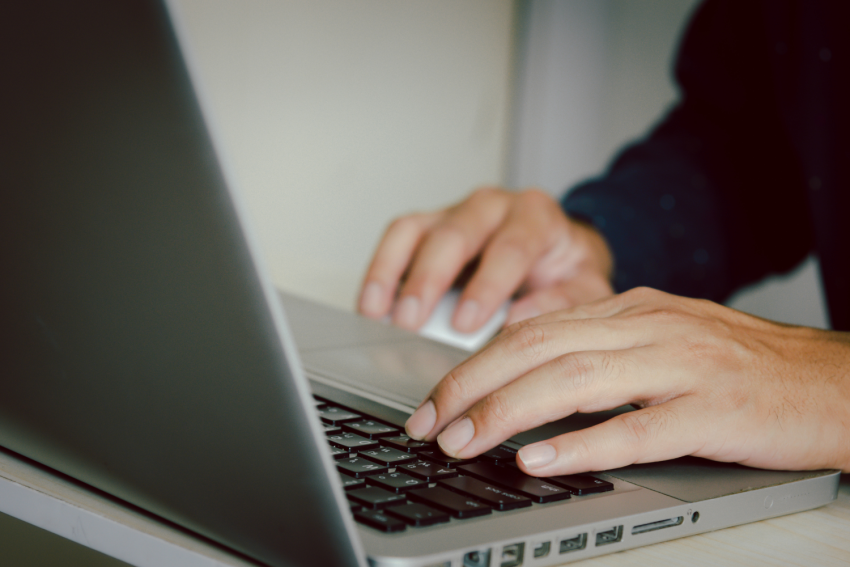 Nahaufnahme von Händen, die auf einer Laptop-Tastatur tippen – Symbolbild für SEO-Optimierung und digitale Arbeit