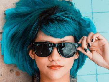 Junge Friseurin schneidet konzentriert die Haare eines männlichen Kunden im Salon – handwerkliches Arbeiten mit Präzision und Stilgefühl.