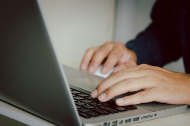 Nahaufnahme von Händen, die auf einer Laptop-Tastatur tippen – Symbolbild für SEO-Optimierung und digitale Arbeit